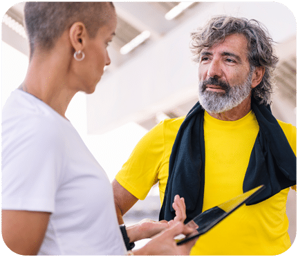 Certified fitness trainer guiding a client through a personalized exercise plan as part of recovery wellness programming
