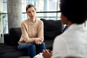 a woman sitting in a counseling session with a psychotherapist