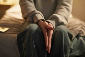 person in hoodie sitting on bed with clasped hands 2026 06 22 22 08 38 utc 1