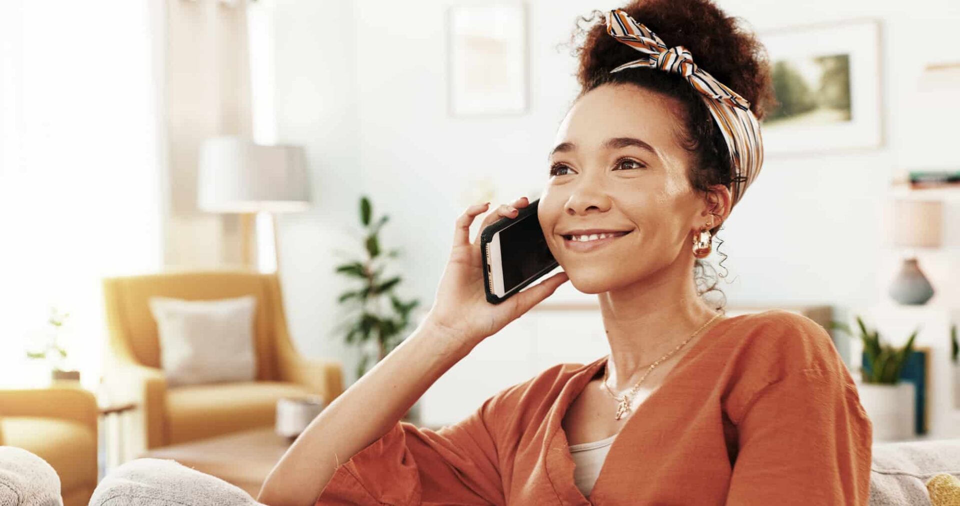 happy woman chatting on cellphone in living room 2026 01 09 10 28 07 utc 1